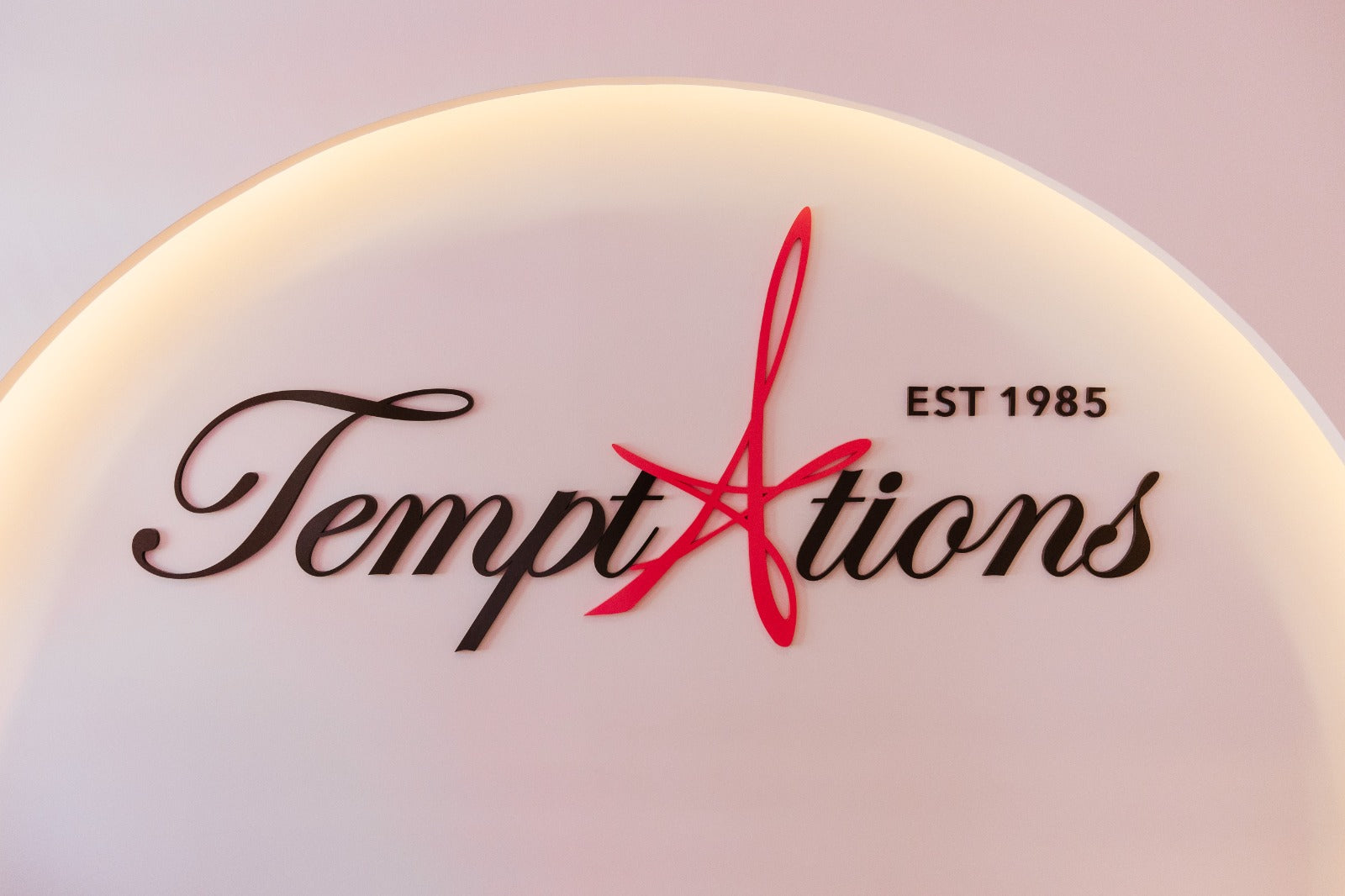 Temptations logo displayed on a wall, featuring a prominent red star as part of the design.