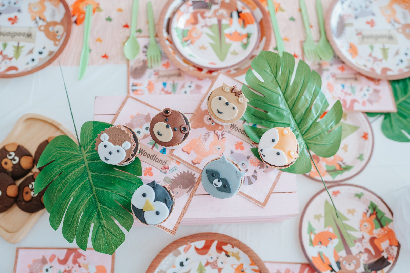 A table set with plates and napkins featuring various animal designs, creating a whimsical dining atmosphere.
